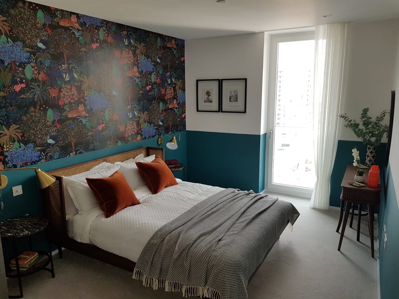 A feature wall “La Jardin du palais “by Pierre Frey wallpaper in a bedroom. The designers have chosen a bright colour for the lower part of the walls to be painted to compliment the wallpaper.