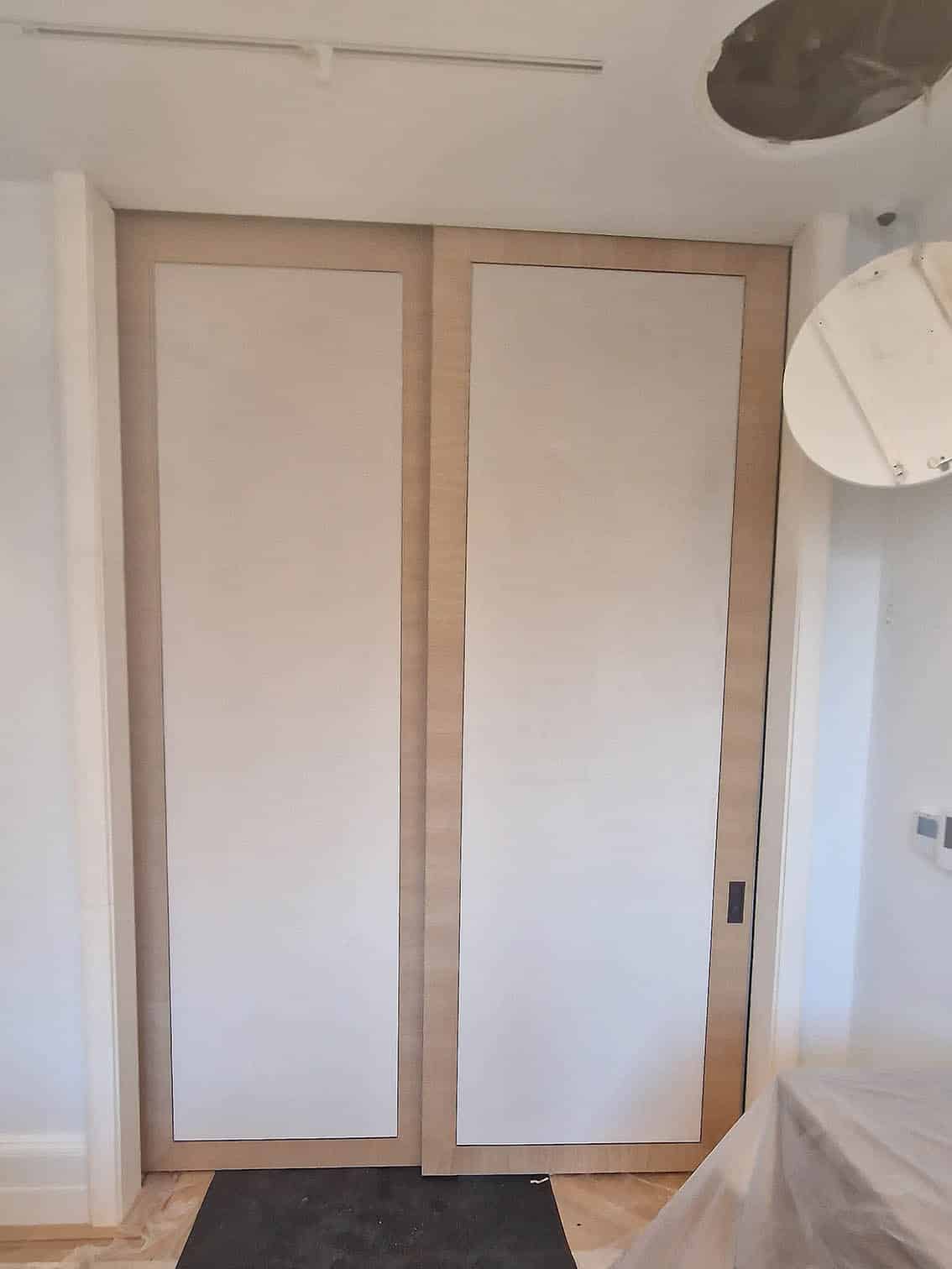 Phillip Jeffries Velvet Cocoon wallpaper professionally installed on a double sliding door in white.