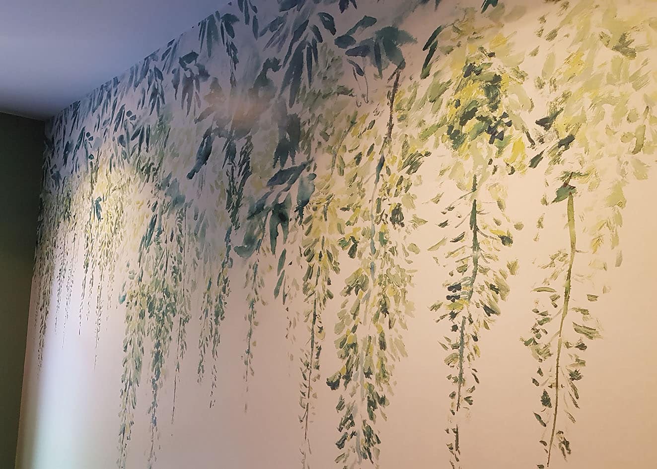 featured wall with green leaves print wallpaper installed by professional wallpaper hangers.