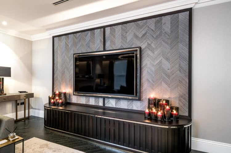 Professional installation of Omexco silver natural wallcovering on a wall with a TV in Chigwell.