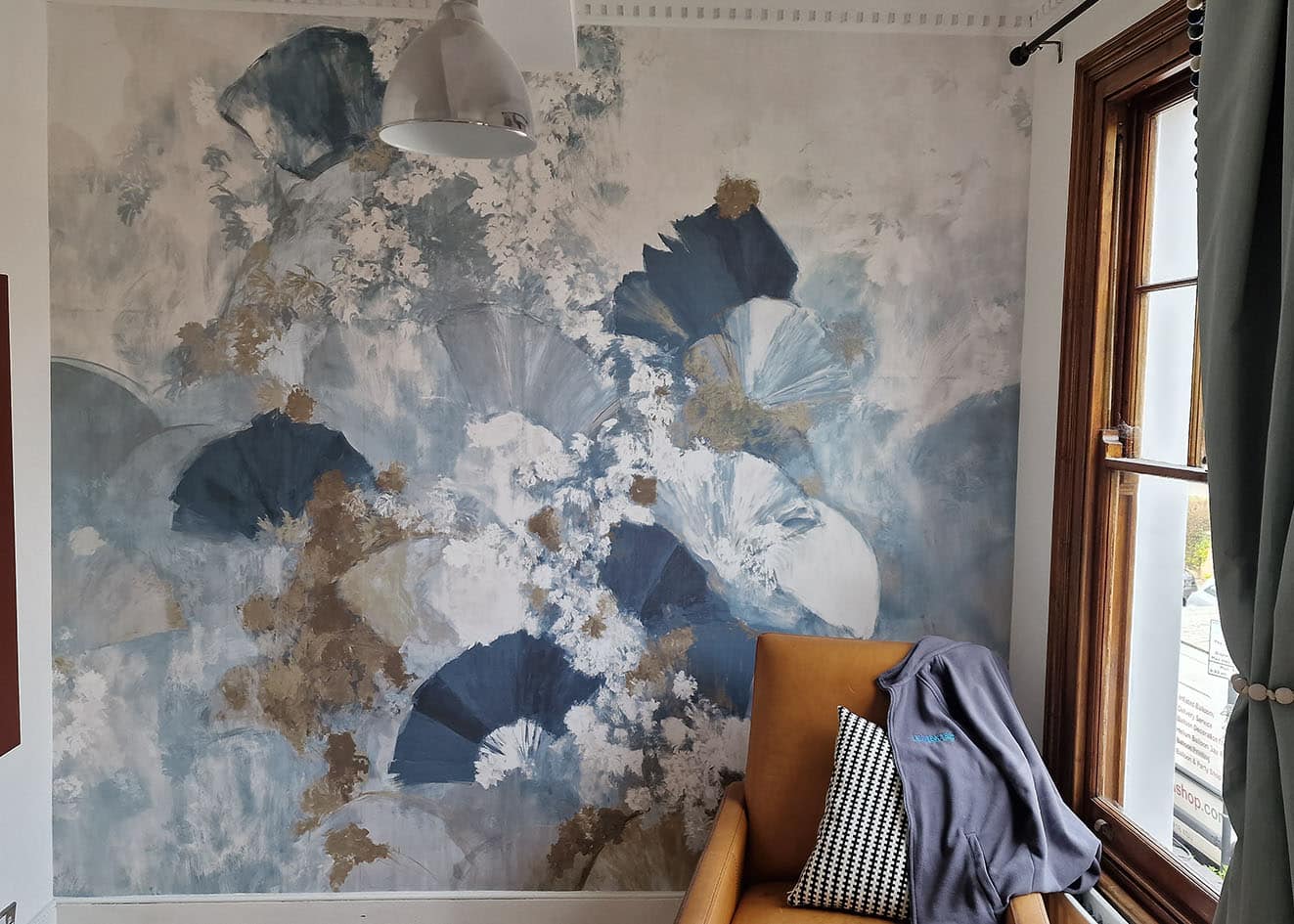 feature wall wallpaper mural with abstract flowers in blue and golden colour installation on a wall.