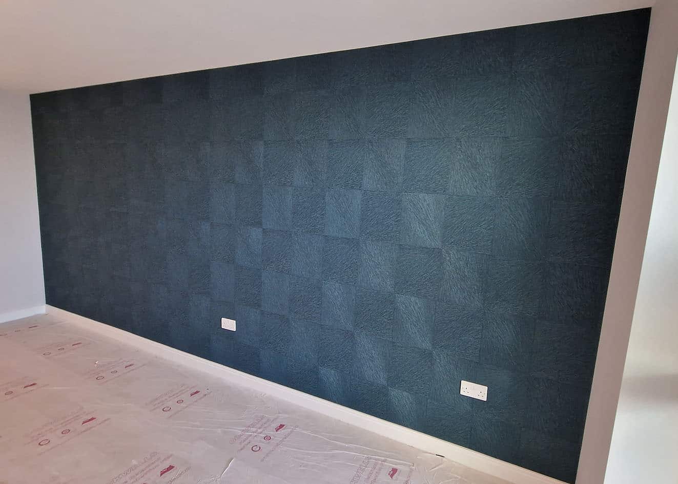Feature wall wallpaper installation, blue textured wallpaper from Tektura installed by our wallpaper hangers.
