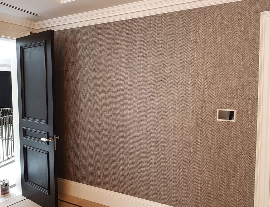  wallpaper installation by professional wallpaper installers , wall with a door open. Wallpaper is in brown natural colour and have a pattern.