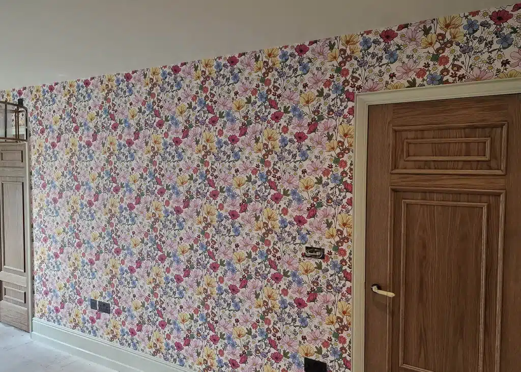 Floral wallpaper installation with pink and red flowers.