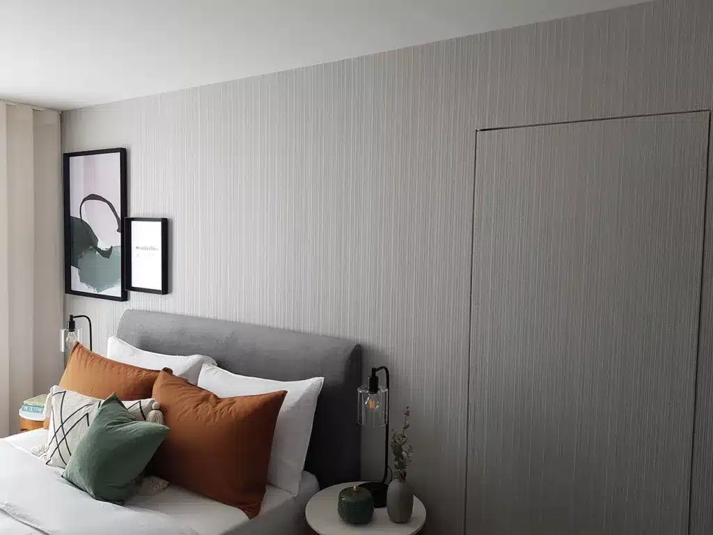 Luxury stripes wallpaper installation in a bedroom , with a door wallpapered.