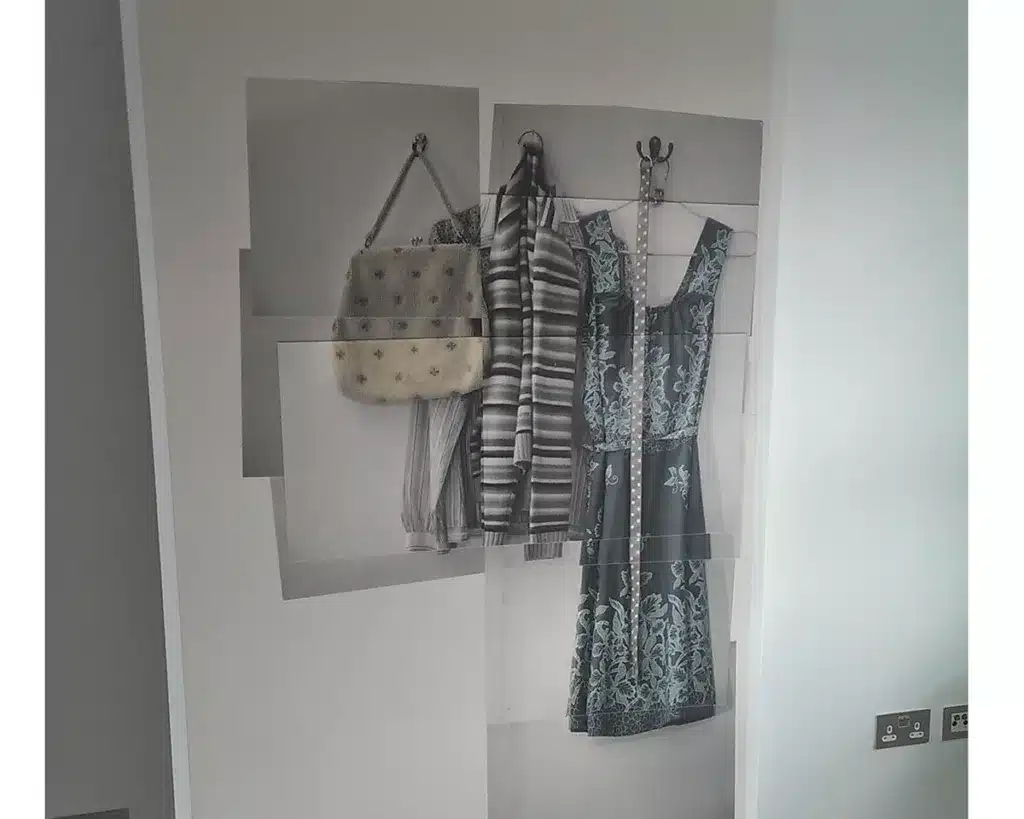 Create a focal point using wallpaper mural with dresses and handbags pictures.