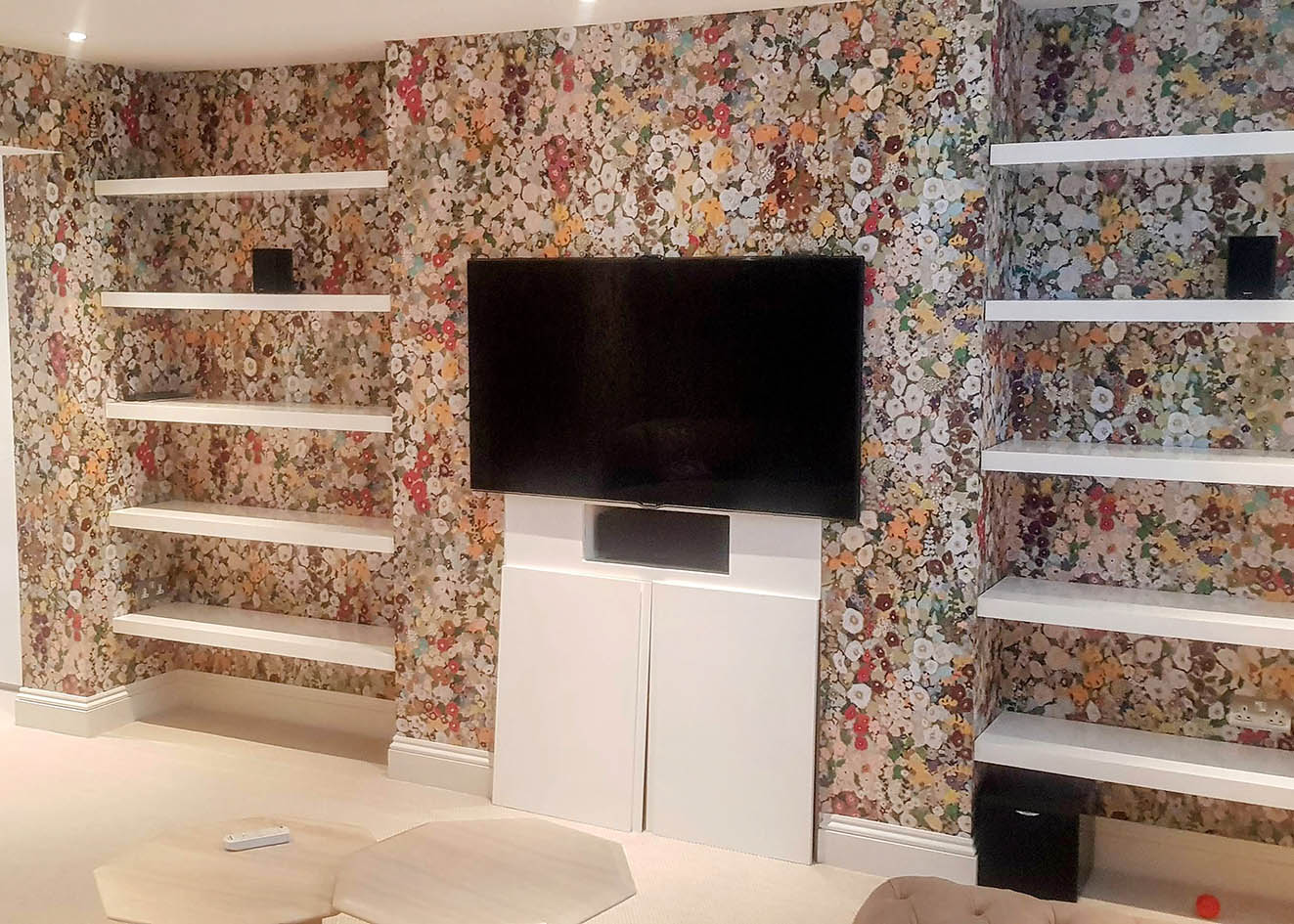 Floral wallpaper installation in a living room colourful.