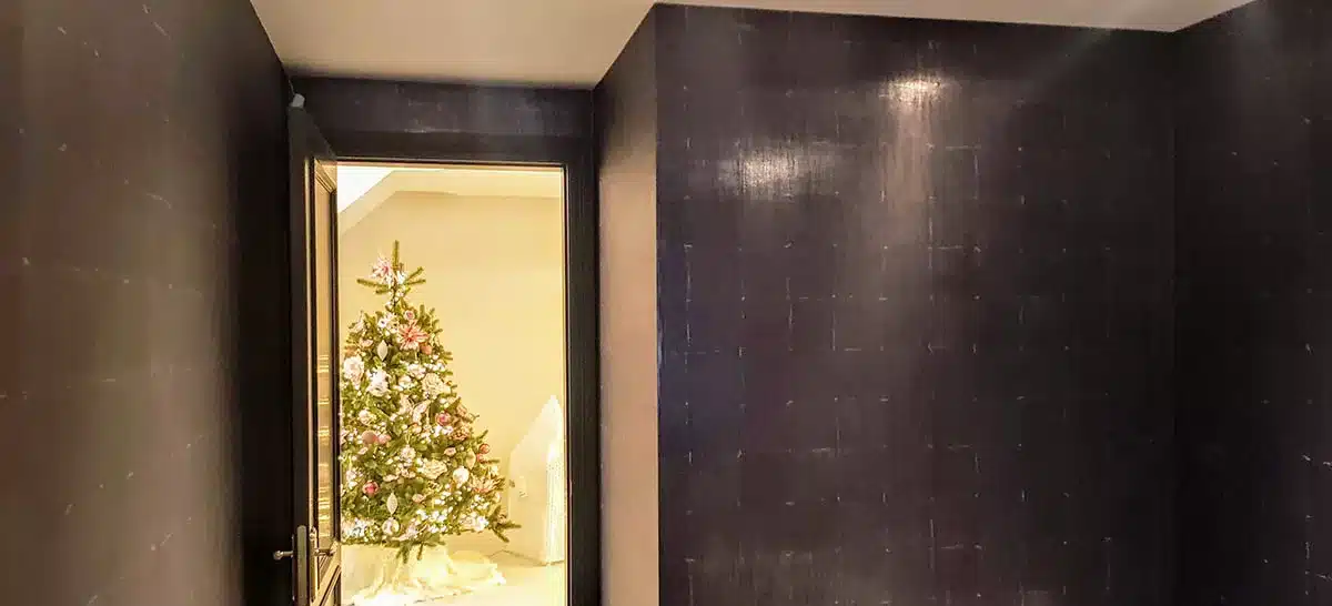 Luxury leather wallpaper in brown colour next to an open door and Christmas tree.
