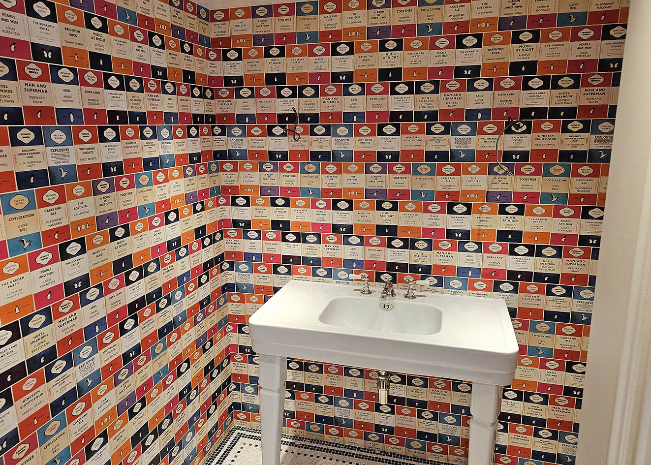 Professionally installed books patterned wallpaper in a bathroom, Putney, London.