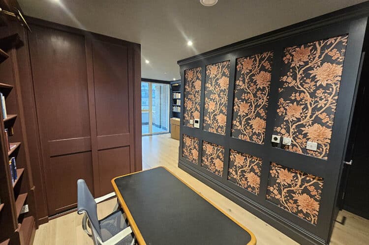 Patterned flowers wallpaper in dark brown and orange flowers installed on a feature wall in Camden Town, London by Bluespec Decorating Limited.