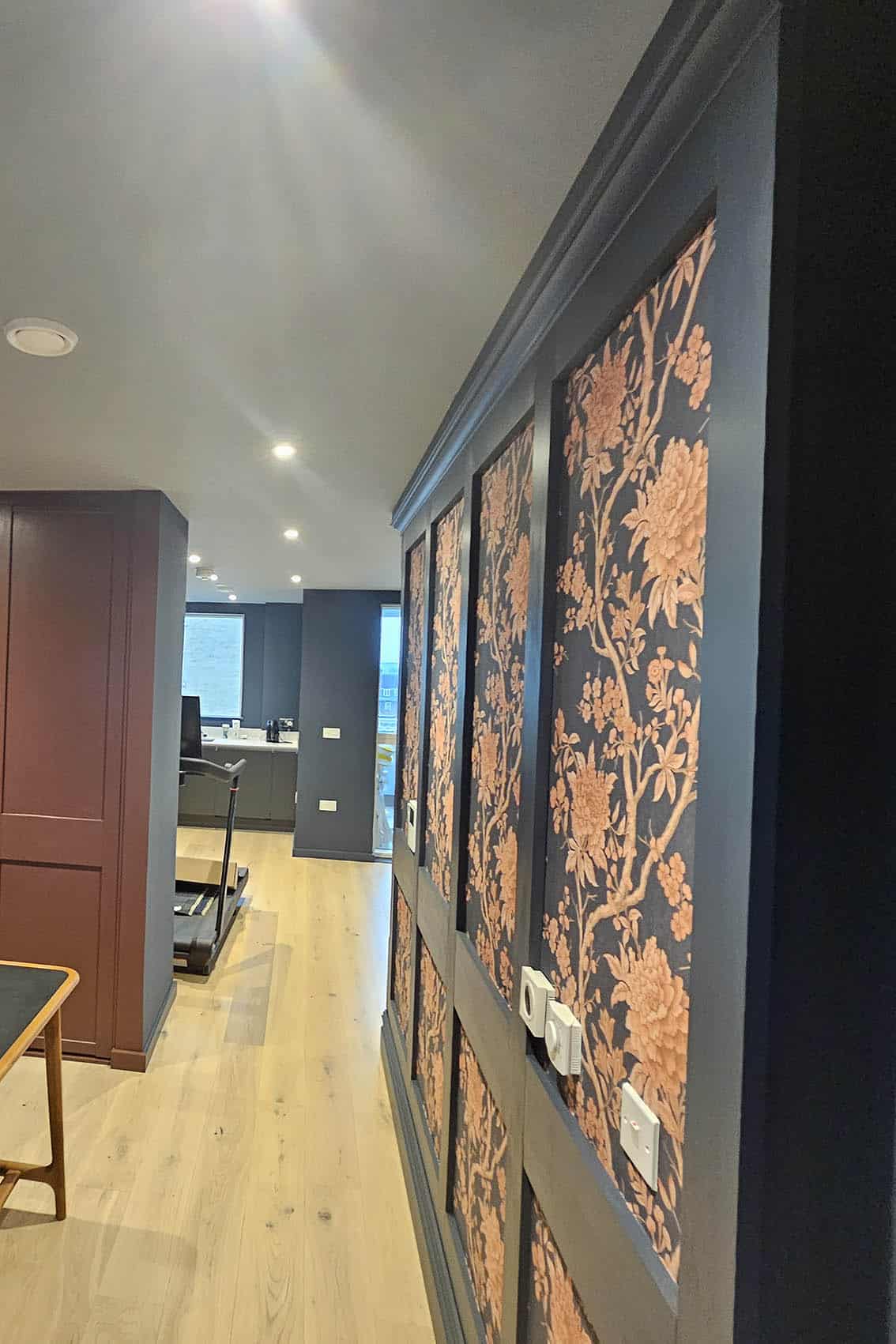 wallpaper-feature-wall-bluespec-decorating-limited Wallpaper feature wall installation in darg grey and orange in Camden town, London.