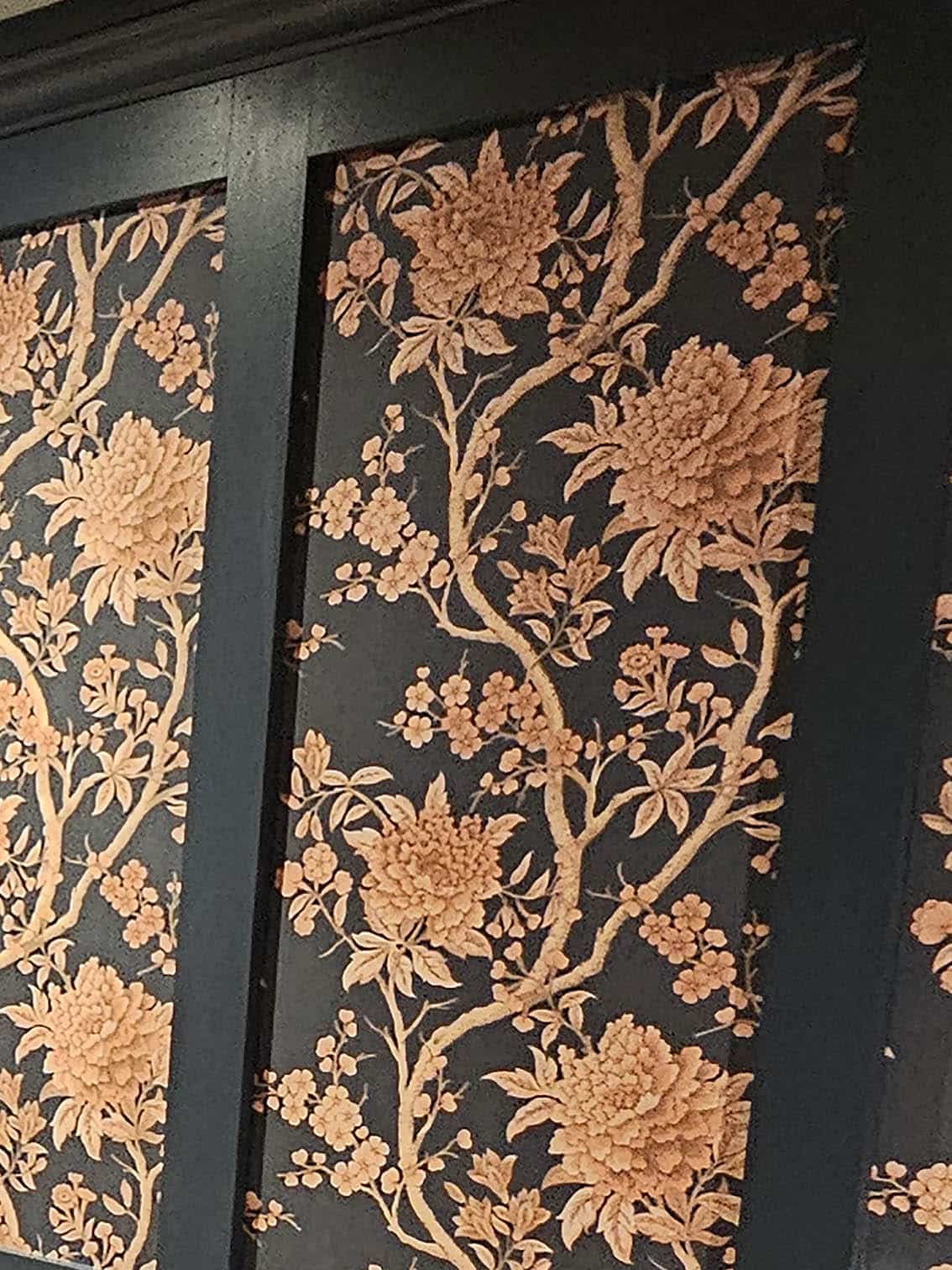 wallpaper-hanging-camden-town-bluespec-decorating-limited Close up of professional wallpaper hanging of a dark grey wallpaper and flowers in Camden Town, London by Bluespec Decorating Limited.