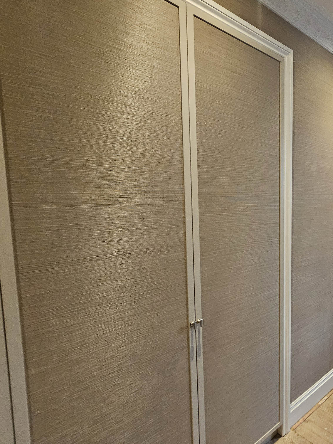 wallpaper-installation-W11 Grasscloth wallpaper hanging in Notting Hill. The wallpaper is installed on walls and wardrobe doors.