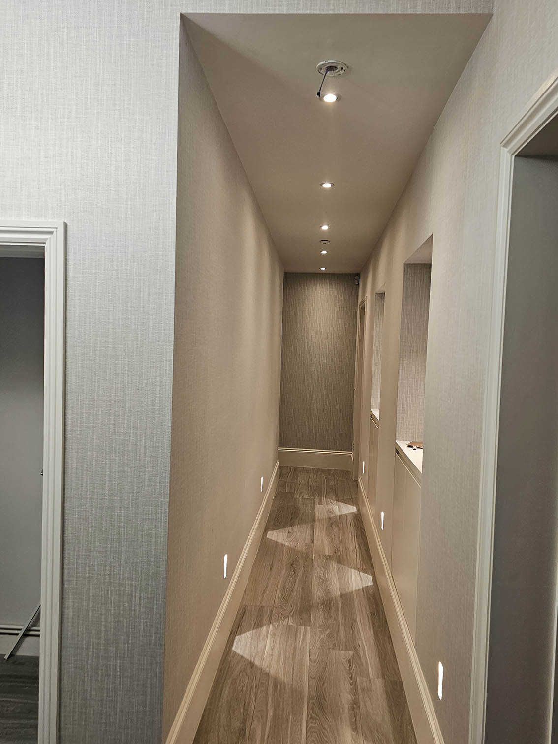 wallpaper-installer-W11 Light grey patterned wallpaper seamlessly installed in a hallway that has niches in Notting Hill, London by Bluespec Decorating Limited.
