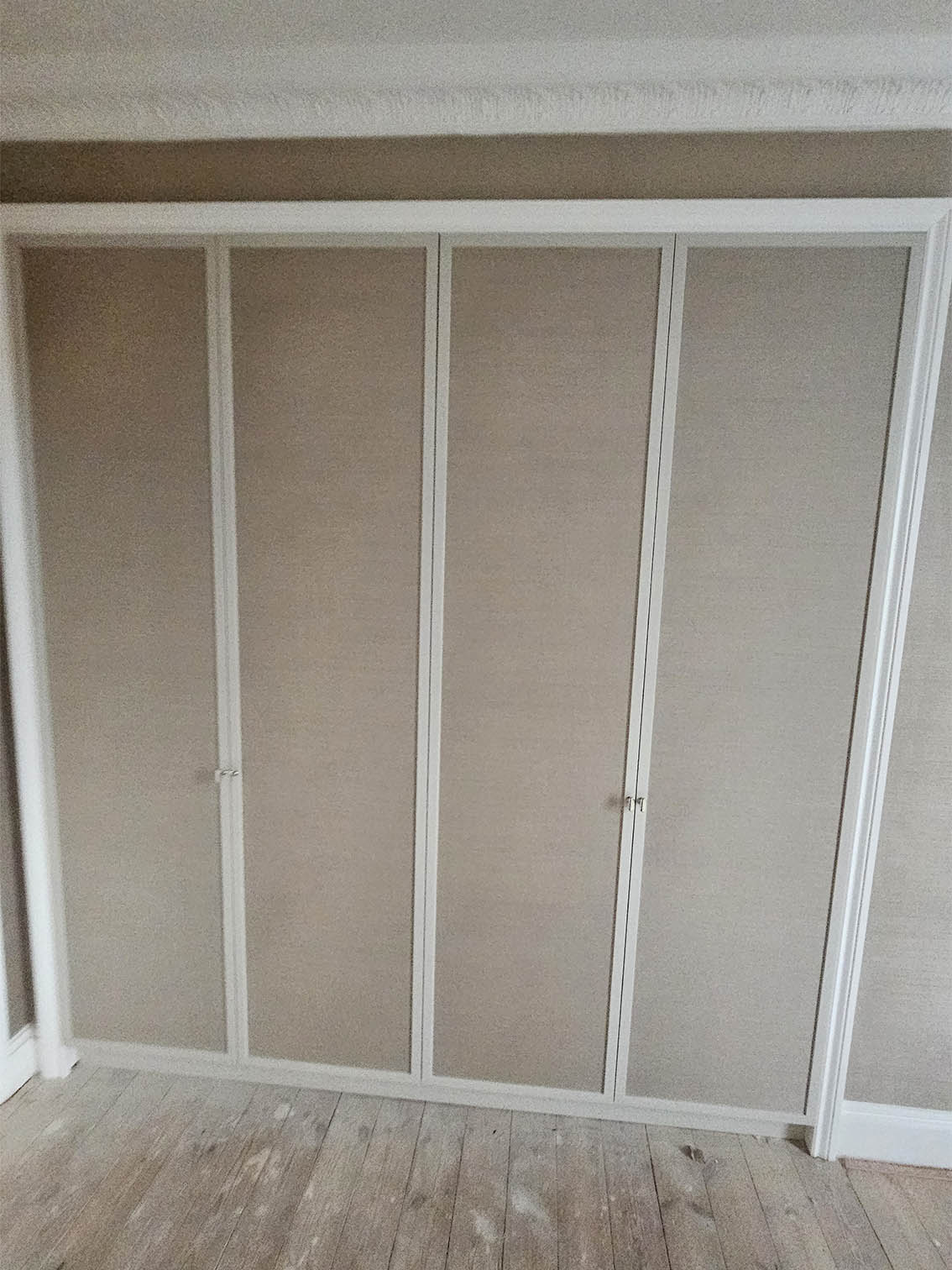 wallpaper-on-wardrobe-doors Wallpapered wardrobe doors by Bluespec Decorating Limited wallpaper installation service. Wallpaper in in dark beige and is grasscloth, natural wallpaper.