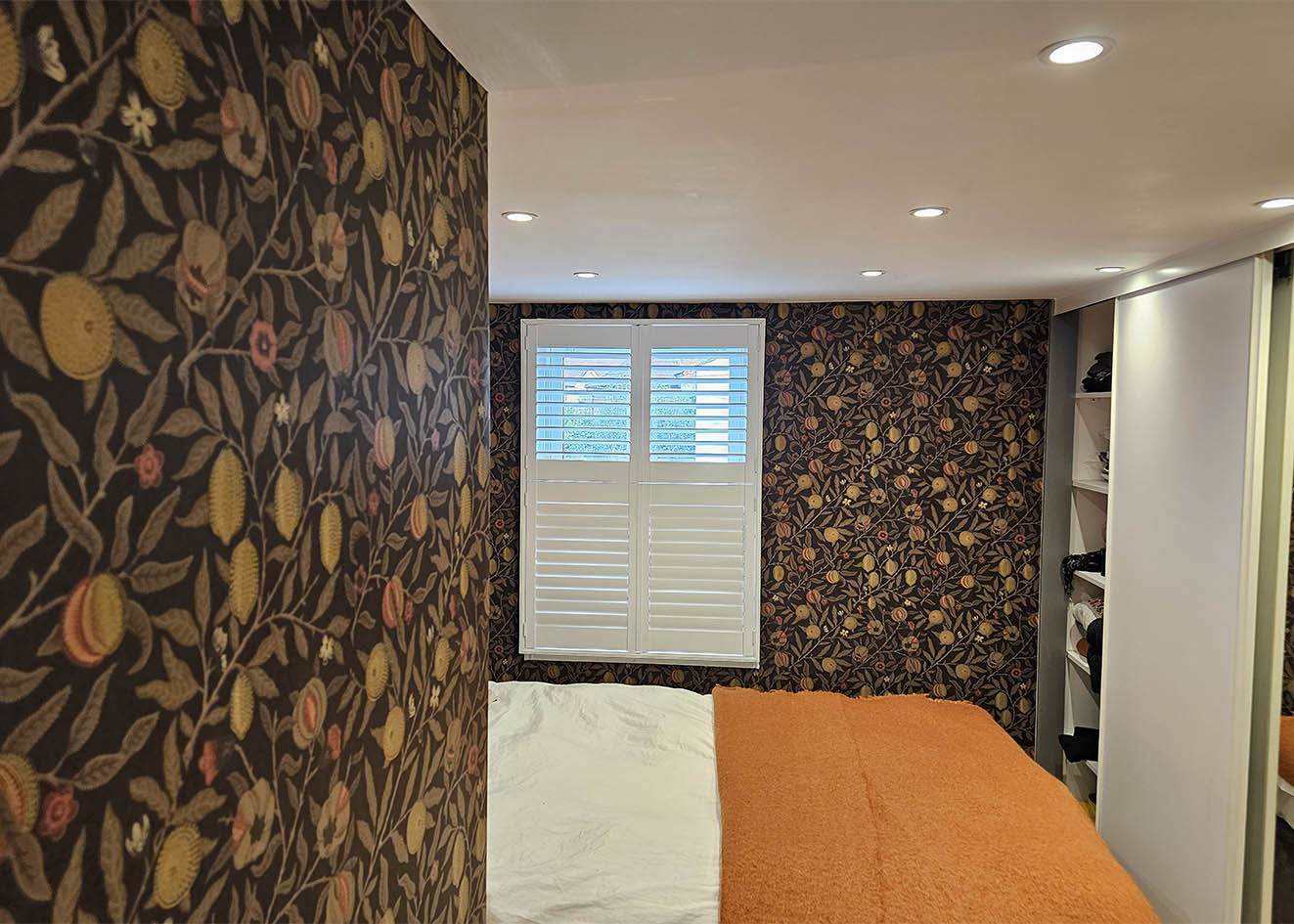 fruit-wallpaper-installation-Barnes-London Wallpaper installation in Barnes, London. A rich botanical print on dark background with trailing fruit and foliage — pattern-matched across a bedroom.